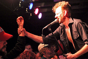 An audience member helps JD demonstrate<br>the ASL sign for the letter O at a show in<br>Asheville, North Carolina, March 2016.