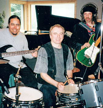 Recording session for "Holidaze," featuring Alan White (drums), Randy Hansen (guitar), and Mike Raine (vocals)
