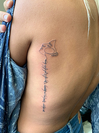 Corey's wife with her Pink Floyd tattoo. It reads, "We're just two lost souls swimming in a fish bowl, year after year," in Sindarin.